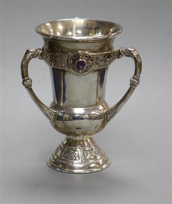 A 1950s Irish Arts & Crafts silver and amethyst coloured stone set Celtic decorated tyg, West & Son, Dublin, 1950?, 10.8cm.